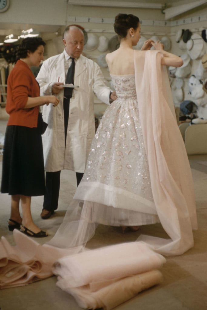 Christian Dior in the salon with a model | Image: Getty
