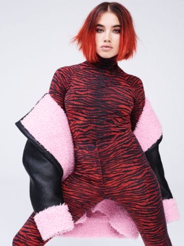 ISAMAYA FFRENCH (make-up artist, based in London and part of the London-based collective, Theo Adams Company) wears an oversized leather jacket with pink faux shearling lining, with matching tiger print jersey rollneck top and high waisted leggings.