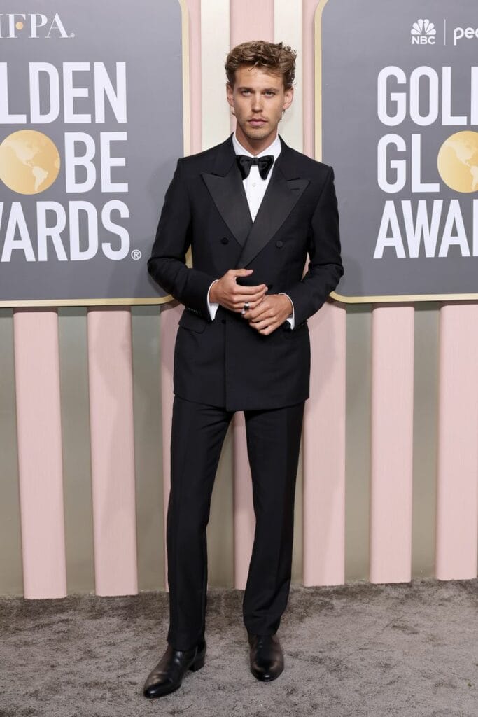 Austin Butler wears a black three-piece tuxedo with satin lapels, white evening shirt, black satin bow tie and ankle boots from Gucci and Cartier. 
