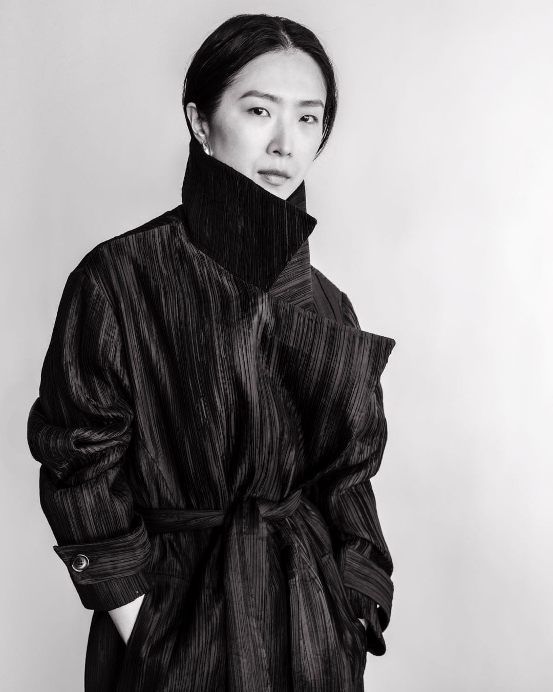 Rain Chan, founder of Cahaya Studios, wearing a black pleated trench coat
